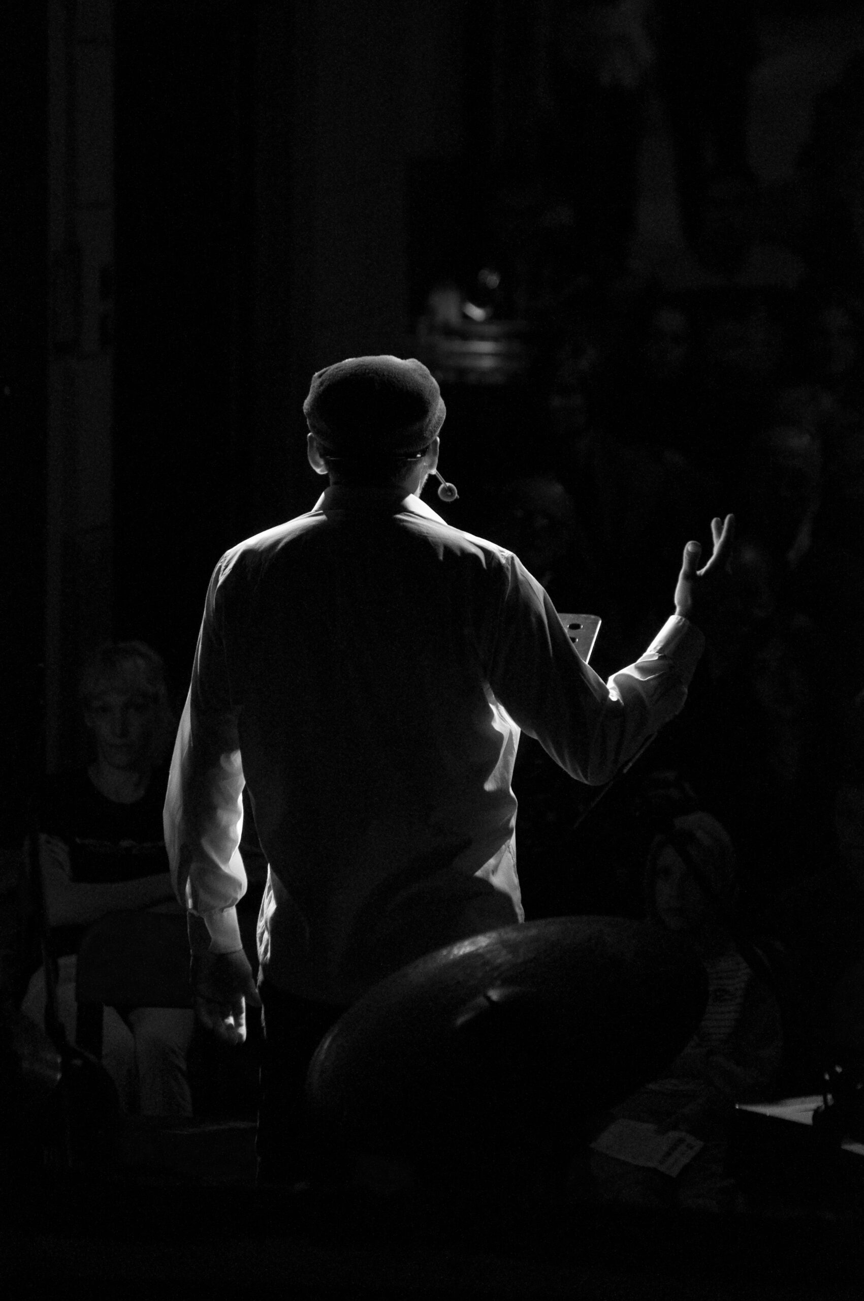 Silhouette of a conductor before an audience, evoking the atmosphere of Italy's high-fidelity gala events